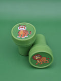 Two green containers with cartoon tiger and lion designs on a green background