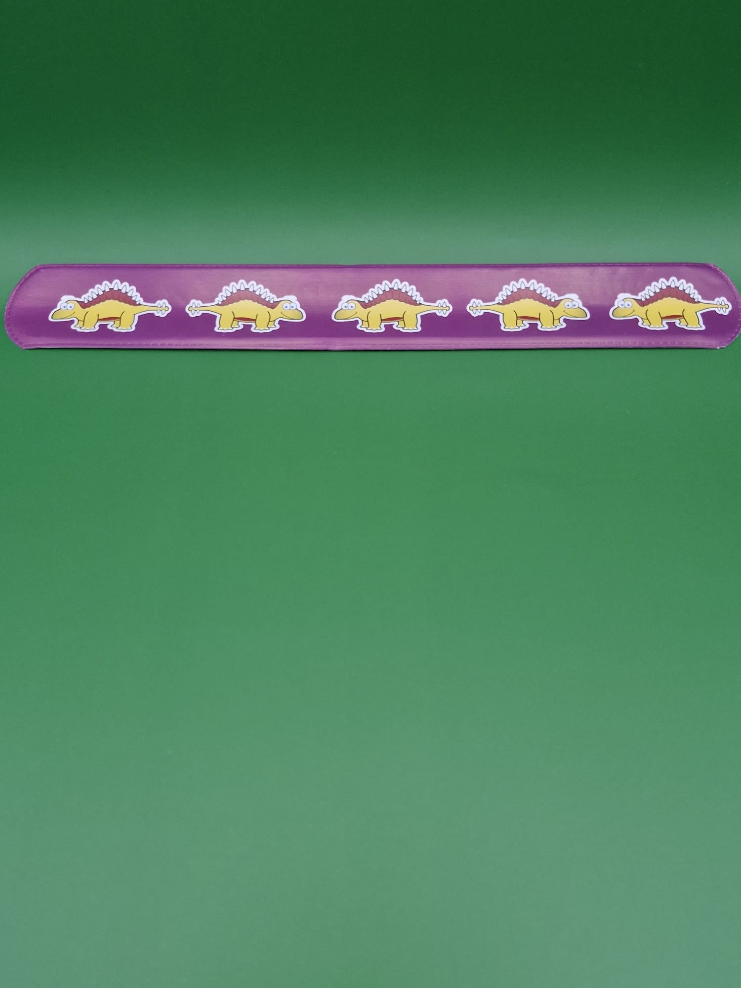 Purple strip with dinosaur illustrations on a green background