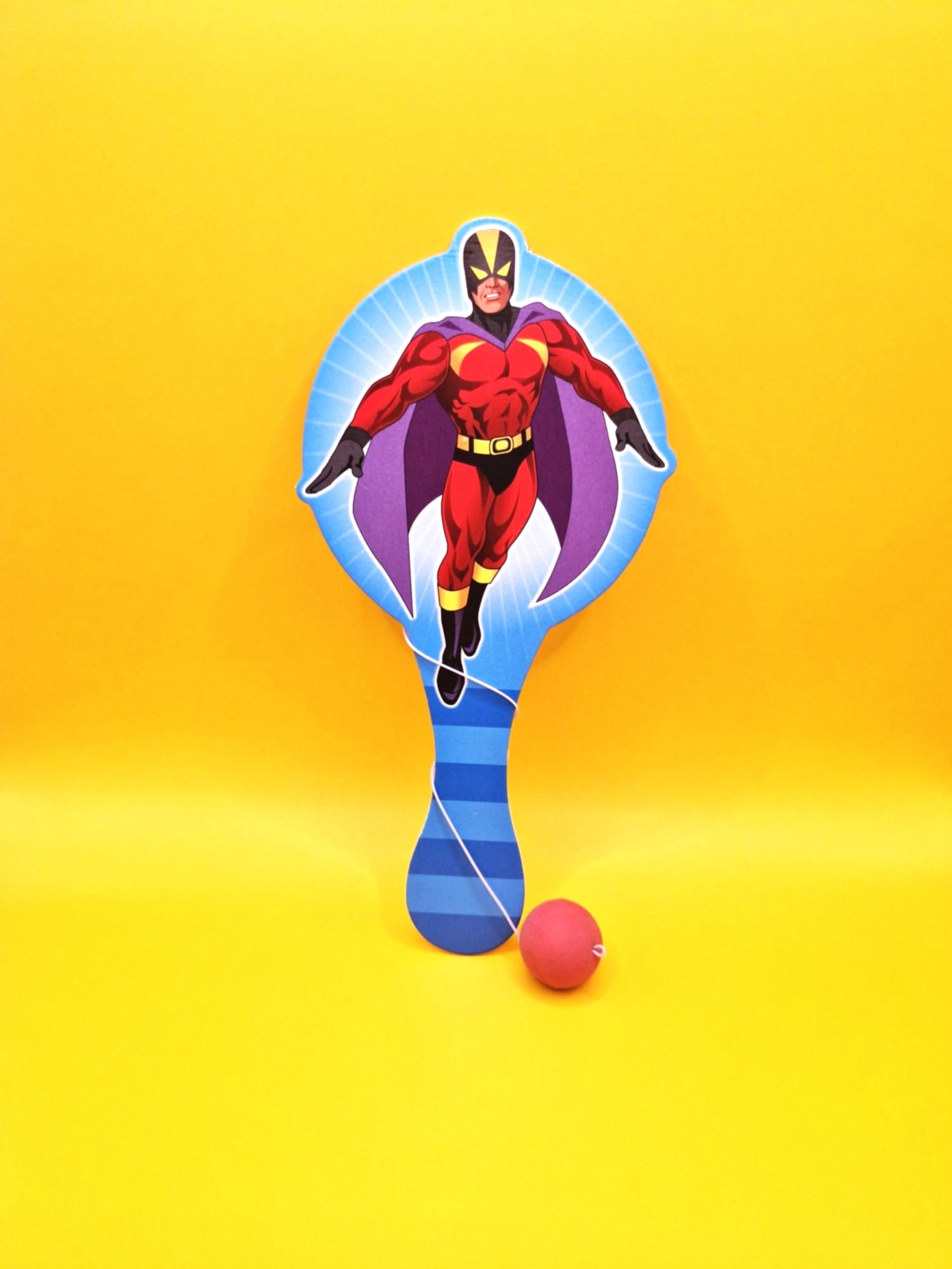 Superhero character on a paddle with a ball against a yellow background