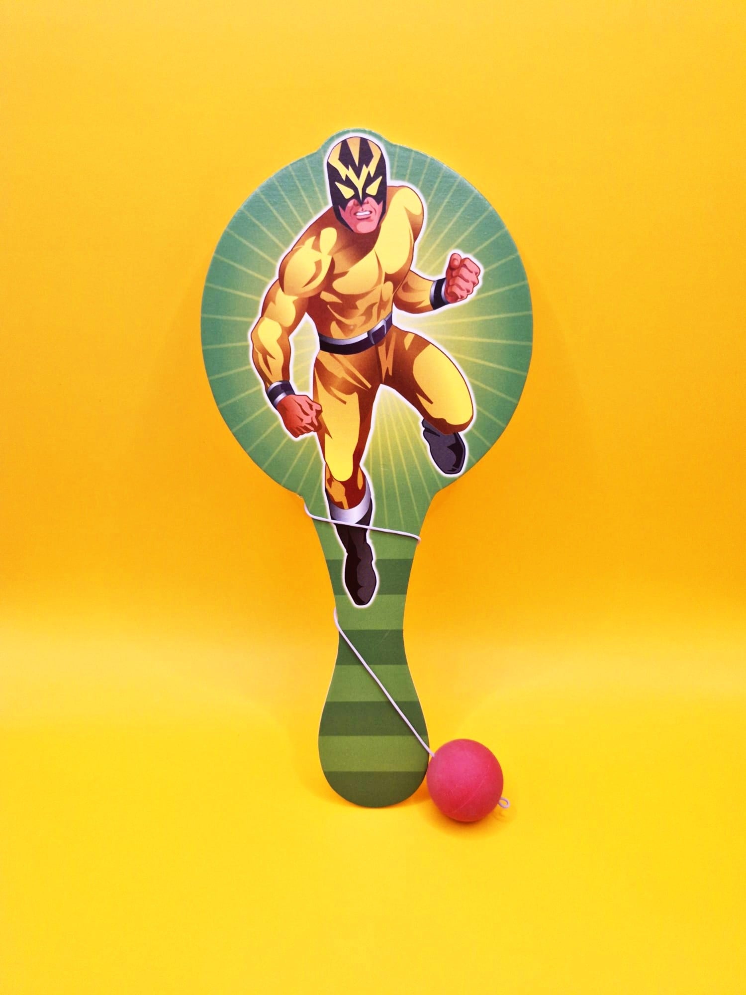 Superhero on a paddle with a pink ball against a yellow background