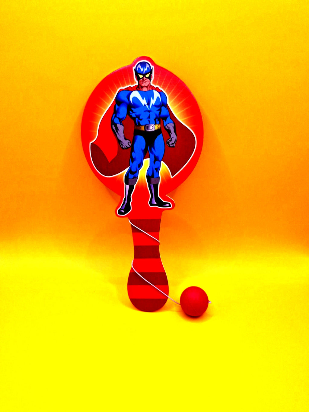Superhero-themed paddle ball set on a yellow background