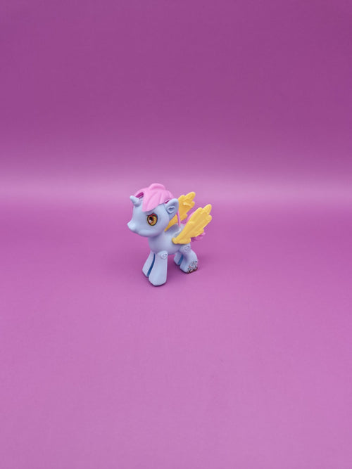 Small toy unicorn with pink hair and yellow wings on a pink background