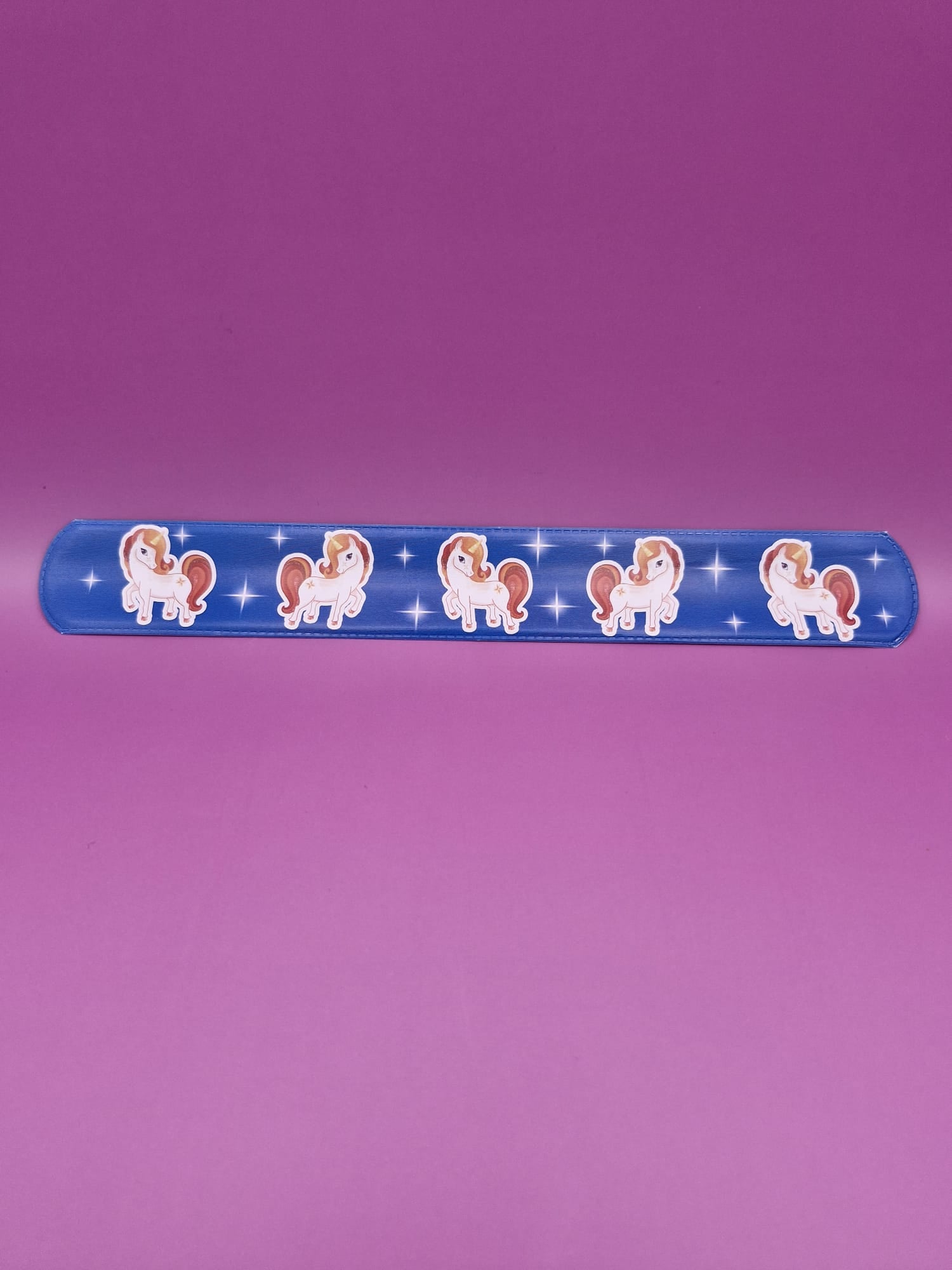 Snap bracelet with a unicorn illustrations on a purple background