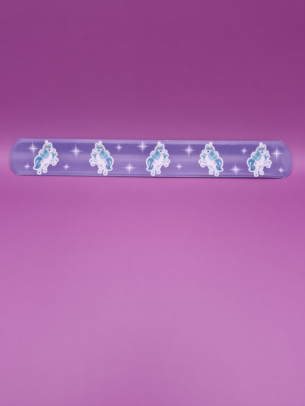 Purple snap bracelet with unicorn designs on a purple background
