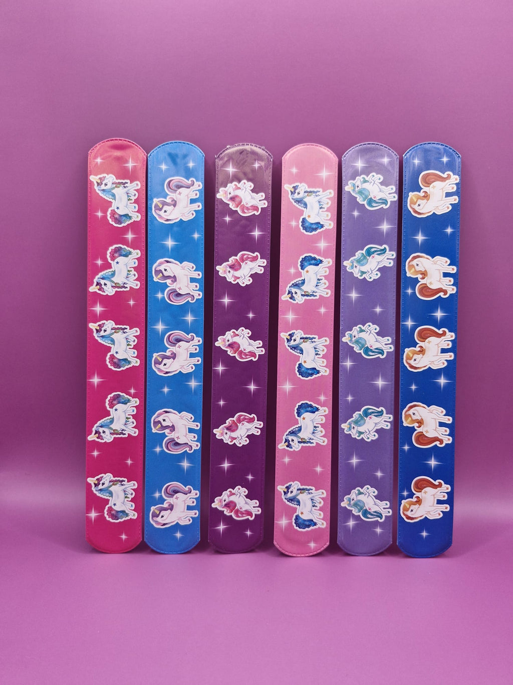 Set of colourful slap bracelets with unicorn characters on a purple background