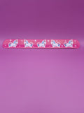 Pink snap bracelet with unicorn designs on a purple background