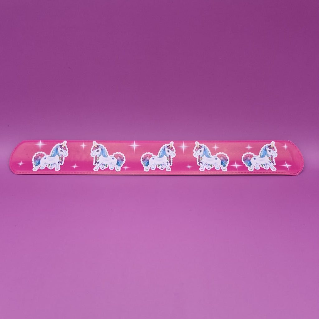 Pink snap bracelet with unicorn designs on a purple background