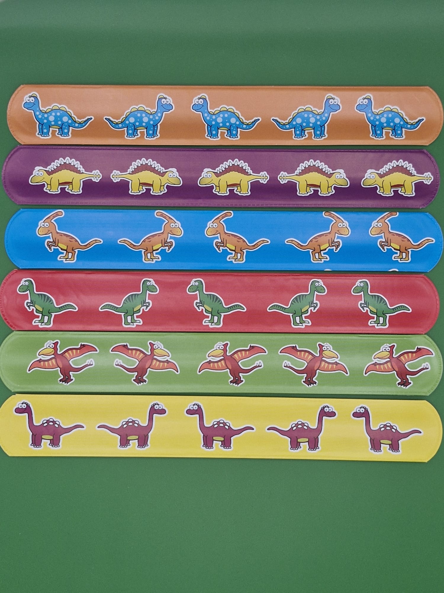 Set of colorful snaps with dinosaur designs on a green background